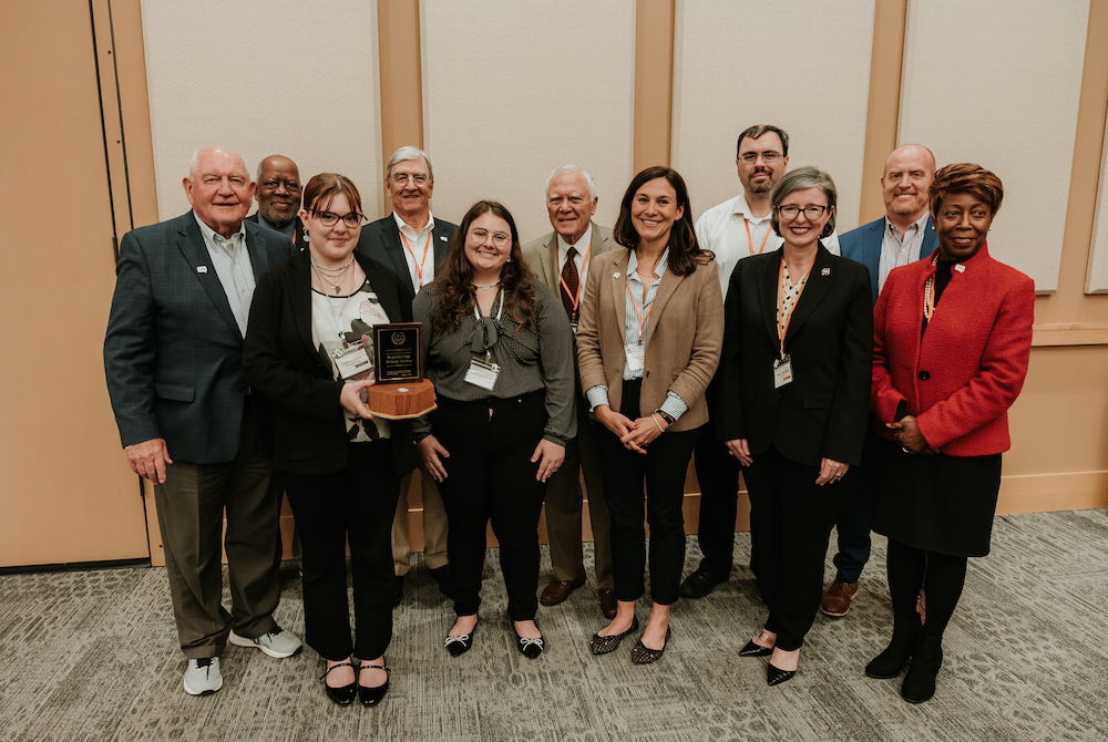 Valdosta State University (VSU) debate team members Gabbi Lorentz, left (holding trophy), and Reagin Jones pose with Chancellor Perdue and the judges after the VSU team was named the inaugural winner of the University System of Georgia’s (USG) Regents Cup Debate.