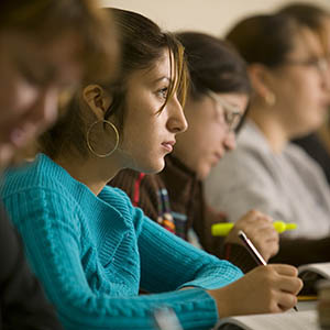 A site shot of two students in classroom listening to the teacher.